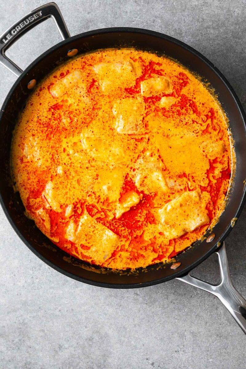 Large even-sized chunks of white fish cooked in a red curry coconut sauce.