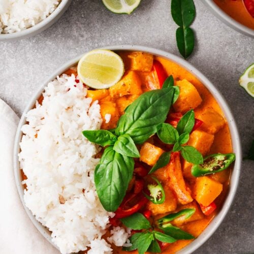 A bowl of butternut squash Thai curry with steamed jasmine rice.