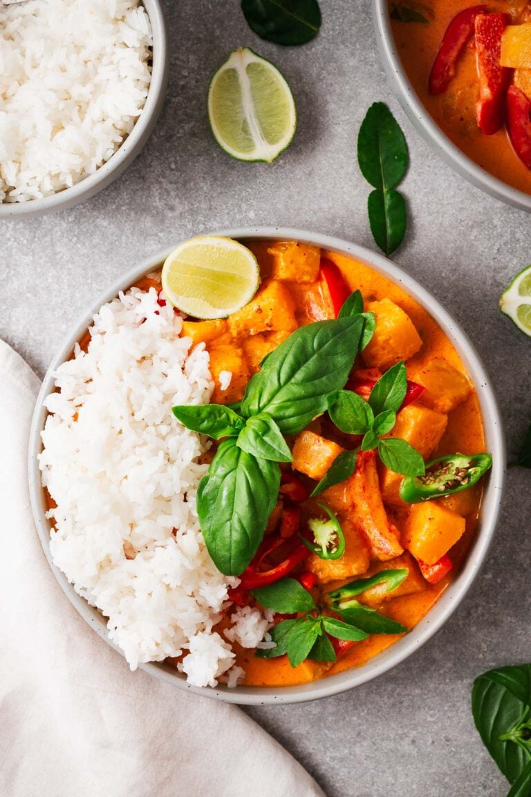 A bowl of butternut squash Thai curry with steamed jasmine rice.